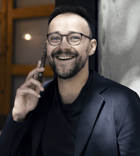 Álvaro Souza sorrindo enquanto fala ao telefone